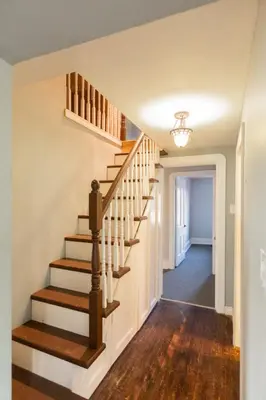 a staircase in a home with white walls and wooden floors at Barrie Bliss 3BR Haven near Centennial Beach in Barrie