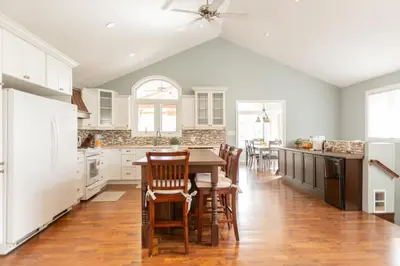 a kitchen with white cabinets and a table and chairs at Barrie Bliss 3BR Haven near Centennial Beach in Barrie
