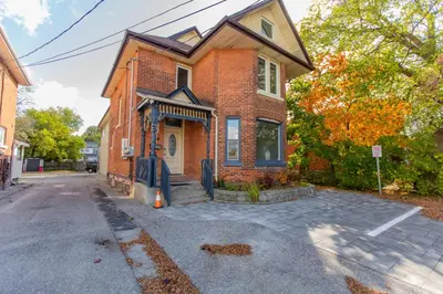 a brick house on a street with a driveway at Barrie Bliss 3BR Haven near Centennial Beach in Barrie
