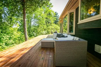 a porch with a couch on a wooden deck at 5BR Riverfront Retreat w Firetable BBQ and Deck in Orangeville