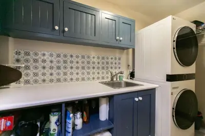 a kitchen with blue cabinets and a sink at 5BR Riverfront Retreat w Firetable BBQ and Deck in Orangeville