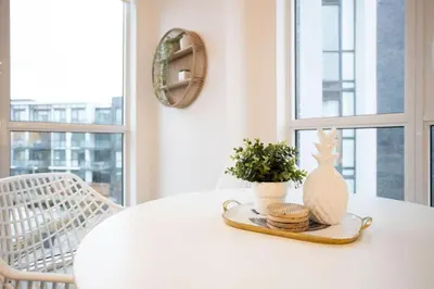 a white table with a vase and a plant on it at Amazing 2BR 2BA Resort Condo w Balcony and Parking in Barrie