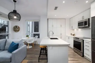 a kitchen and living room with a couch and a table at Amazing 2BR 2BA Resort Condo w Balcony and Parking in Barrie