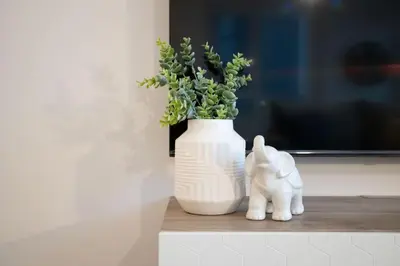 a white vase sitting on a shelf with a plant at Amazing 2BR 2BA Resort Condo w Balcony and Parking in Barrie