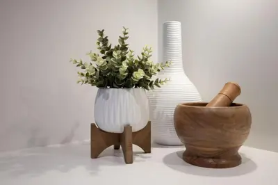 a white vase with flowers in it next to a wooden bowl at Amazing 2BR 2BA Resort Condo w Balcony and Parking in Barrie