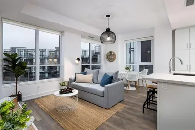 a kitchen and living room with a couch and a table at Amazing 2BR 2BA Resort Condo w Balcony and Parking in Barrie