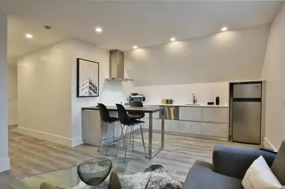 a kitchen and living room with a table and chairs at The VanderMarck Boutique Hotel in Collingwood