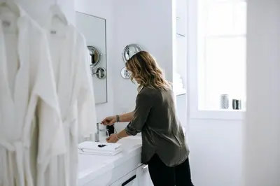 a woman standing in front of a bathroom sink at The VanderMarck Boutique Hotel in Collingwood