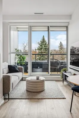 a living room with a couch and a large window at Designer Yonge & Eglinton Gem, Parking, 65 TV in Toronto
