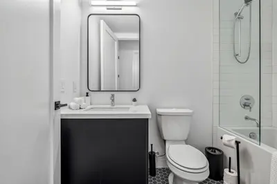 a bathroom with a sink and a toilet and a mirror at Designer Yonge & Eglinton Gem, Parking, 65 TV in Toronto
