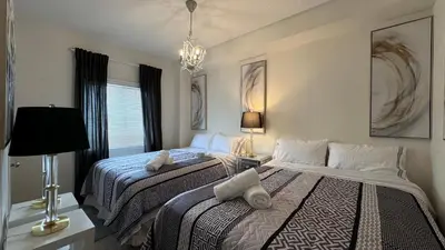 a bedroom with two beds and a chandelier at 9 Queen Beds, 18 Guests-Kleinburg Luxe Crown Town Residence in Vaughan