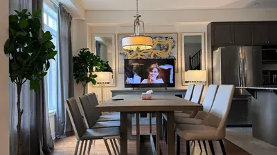 a dining room with a table and chairs and a television at 9 Queen Beds, 18 Guests-Kleinburg Luxe Crown Town Residence in Vaughan