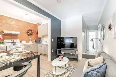 a kitchen and living room with a couch and a table at Boutique 2BR Apartment on James St North Sleeps 6 in Hamilton