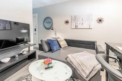 a living room with a couch and a table at Boutique 2BR Apartment on James St North Sleeps 6 in Hamilton