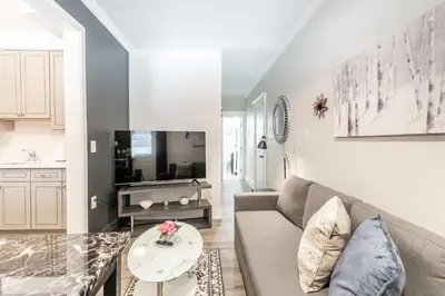 a living room with a couch and a table at Boutique 2BR Apartment on James St North Sleeps 6 in Hamilton