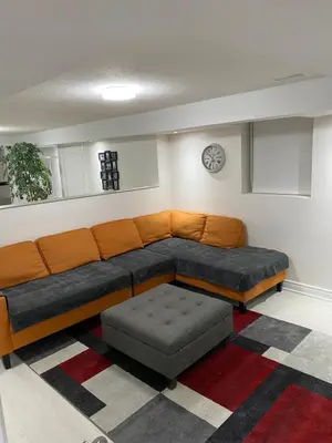 a couch and ottoman in a living room at Akhtar's Residence in Mississauga