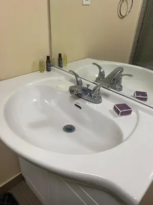 a bathroom sink with two faucets and a mirror at Akhtar's Residence in Mississauga