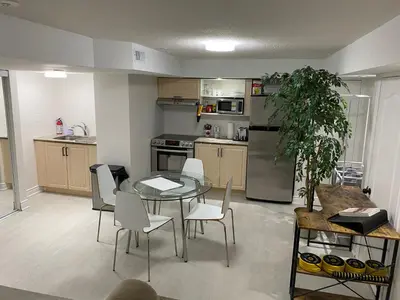 a kitchen with a table and chairs and a kitchen with a refrigerator at Akhtar's Residence in Mississauga