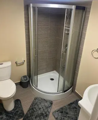a bathroom with a shower with a toilet and a sink at Akhtar's Residence in Mississauga