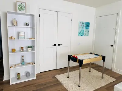 a room with a table and white shelves at Lovely Beachside Oasis 2BD in Port Dover in Port Dover