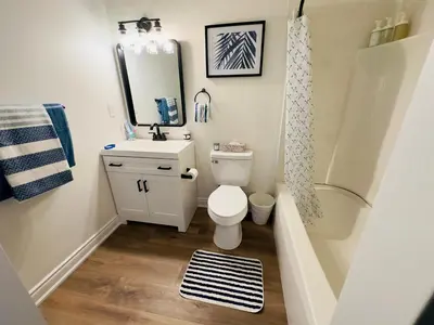 a bathroom with a toilet and a sink and a mirror at Lovely Beachside Oasis 2BD in Port Dover in Port Dover