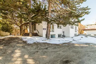 a large white house with trees in the yard at Birch View- Balcony-Backyard-Parking-Sauna-Sleeps 20 in Blue Mountains
