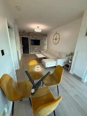 a living room with a glass table and yellow chairs at 2 Bedroom 1 Bathroom renovated fully furnished apartment in Mississauga
