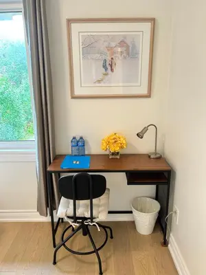 a desk in a room with a chair and a lamp at Super Cosy Peaceful room with Garden view free Parking in Toronto