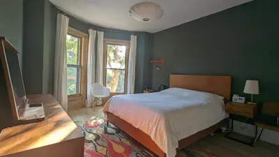 a bedroom with a bed and a desk and window at Stunning Victorian in Downtown in Toronto