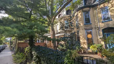 a large brick house with trees in front of it at Stunning Victorian in Downtown in Toronto
