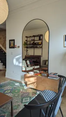 a mirror in a room with a chair and a table at Stunning Victorian in Downtown in Toronto