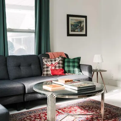 a living room with a couch and a glass table at Bloomfield Bliss - Hot Tub and Walking Distance to Park in Bloomfield