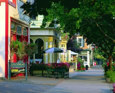a street with a bench and an umbrella in front of a building at Niagara Creekside B&B - Waterfront suite in Niagara Falls