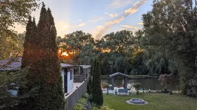 a house with a garden and a lake at Niagara Creekside B&B - Waterfront suite in Niagara Falls