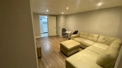 a living room with a white couch and a table at Cozy Basement in Richmond Hill