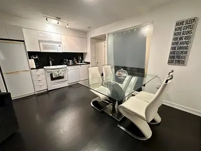 a dining room with a glass table and white chairs at LakeView 2Bdrms 2Baths with 3 real beds and parking in Toronto