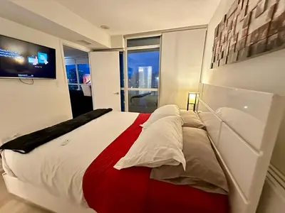 a bedroom with a large bed and a television at LakeView 2Bdrms 2Baths with 3 real beds and parking in Toronto