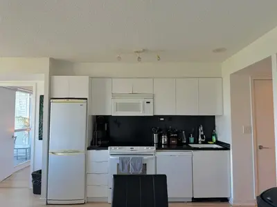 a kitchen with white cabinets and white appliances at LakeView 2Bdrms 2Baths with 3 real beds and parking in Toronto