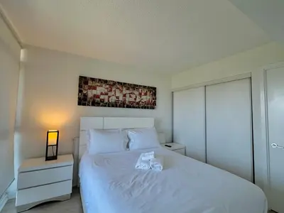 a bedroom with a large white bed with a lamp at LakeView 2Bdrms 2Baths with 3 real beds and parking in Toronto