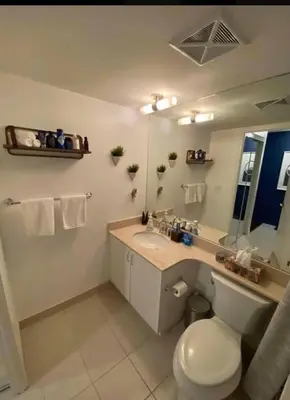 a bathroom with a toilet and a sink and a mirror at Luxury Downtown Condo with CN tower views, Pool Access, Gym,Free Parking upon request at booking, accommodates 4 in Toronto