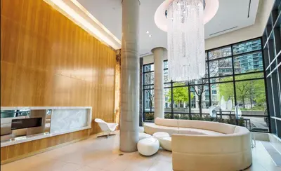 a large lobby with a couch and a chandelier at Luxury Downtown Condo with CN tower views, Pool Access, Gym,Free Parking upon request at booking, accommodates 4 in Toronto