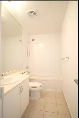 a white bathroom with a toilet and a sink at Luxury Downtown Condo with CN tower views, Pool Access, Gym,Free Parking upon request at booking, accommodates 4 in Toronto