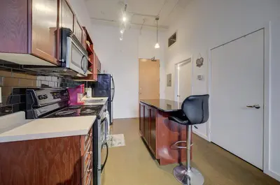 a kitchen with a stove and a chair in it at Entire 1 bedroom in the heart of KW downtown across Google in Kitchener
