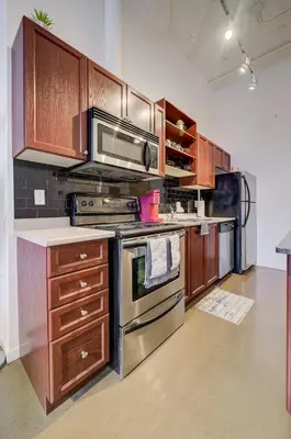 a kitchen with stainless steel appliances and wooden cabinets at Entire 1 bedroom in the heart of KW downtown across Google in Kitchener