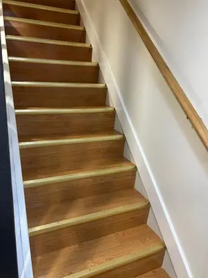 a staircase with wood treads in a house at Luxurious modern basement apartment in Pickering