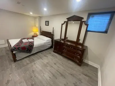 a bedroom with a bed with a mirror and a dresser at CozyHaven A private entrance, comfy basement apartment in Mississauga with free parking Conveniently located with easy access to the airport downtown Toronto major malls and highways for a seamless stay in Mississauga