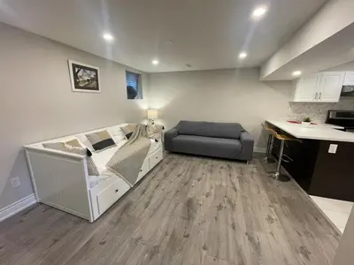 a bedroom with a bed and a desk and a couch at CozyHaven A private entrance, comfy basement apartment in Mississauga with free parking Conveniently located with easy access to the airport downtown Toronto major malls and highways for a seamless stay in Mississauga