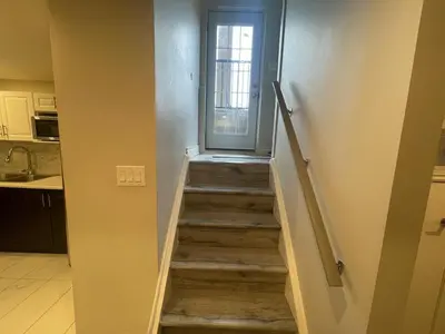 a staircase leading to a door in a kitchen at CozyHaven A private entrance, comfy basement apartment in Mississauga with free parking Conveniently located with easy access to the airport downtown Toronto major malls and highways for a seamless stay in Mississauga