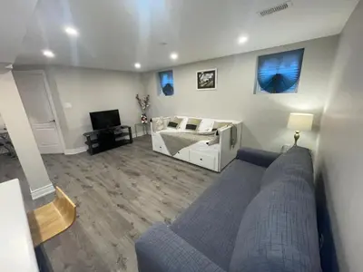 a living room with a couch and a bed at CozyHaven A private entrance, comfy basement apartment in Mississauga with free parking Conveniently located with easy access to the airport downtown Toronto major malls and highways for a seamless stay in Mississauga