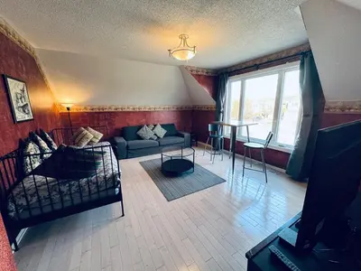 a living room with a couch and a table at Sunnys Home Stays TorontoMississauga Pvt Entrance 2B'Rm Bath Living & Kitchen in Mississauga